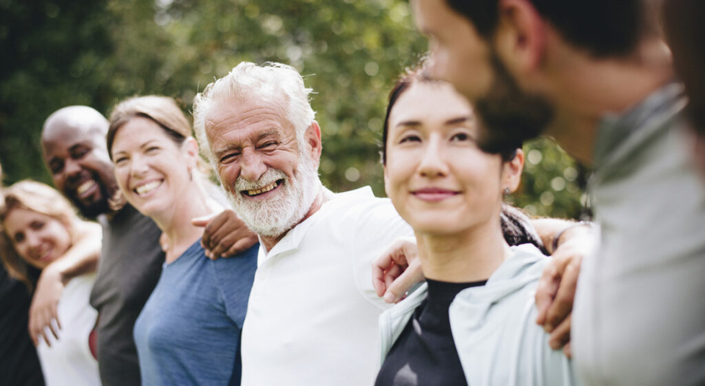 Diverse group with arms around shoulders
